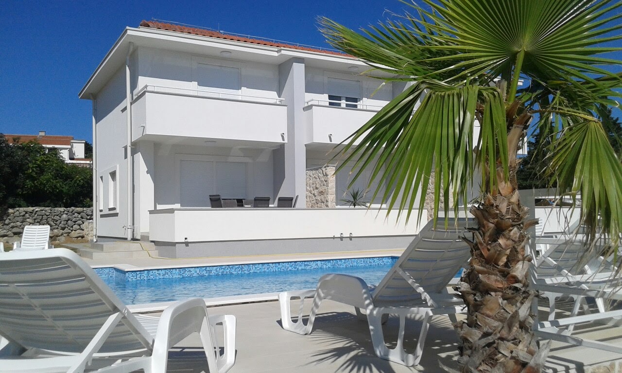 Building exterior with palm tree and pool